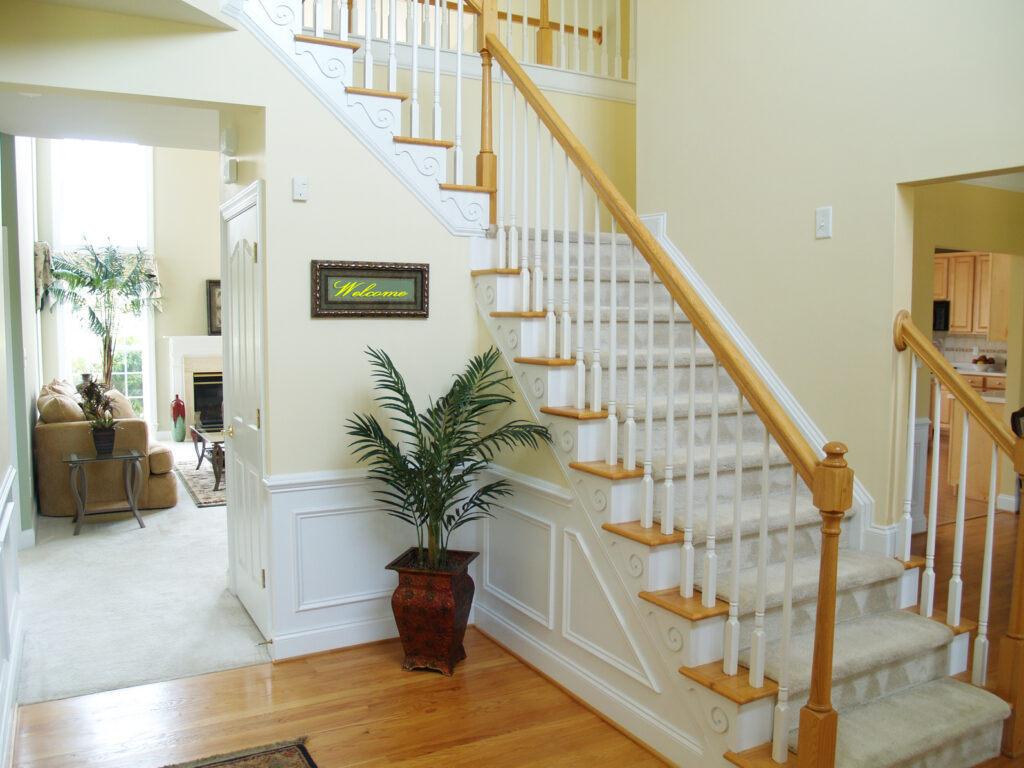 Light tan stair runner rugs in the entrance of the home leading to the living room by AJ Rose in Needham, MA - Lynnfield, MA - Natick, MA - Burlington, MA.