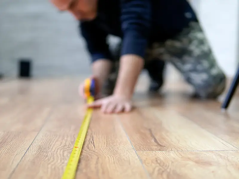 Estimator measuring a floor in a customers home