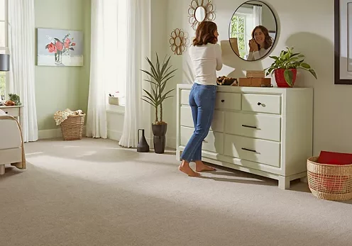 Lady wearing ear ring looking into mirror